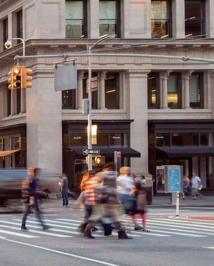 New York City street scene with crowds of people walking through the busy intersection of 23rd and 5th Avenue in Midtown Manhattan